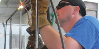 Aircraft welder using oxy-acetylene to weld an aircraft component.
