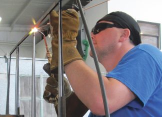 Aircraft welder using oxy-acetylene to weld an aircraft component.