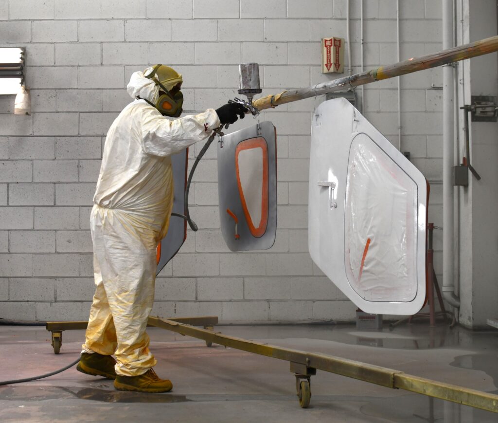 The painter sprays the door planels of a Glasair Sportsman 2+2. [Credit: Mike Davenport]