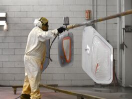 The painter sprays the door planels of a Glasair Sportsman 2+2. [Credit: Mike Davenport]