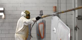 The painter sprays the door planels of a Glasair Sportsman 2+2. [Credit: Mike Davenport]