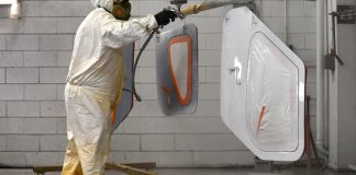 The painter sprays the door planels of a Glasair Sportsman 2+2. [Credit: Mike Davenport]