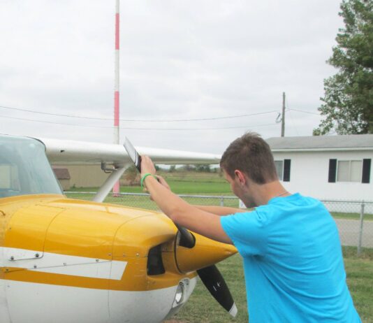 The alternative to bending down as the propeller is pulled through the compression stroke is to keep the back straight and bend the knees slightly, stepping away in a crouch. [Credit: LeRoy Cook]