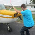 The alternative to bending down as the propeller is pulled through the compression stroke is to keep the back straight and bend the knees slightly, stepping away in a crouch. [Credit: LeRoy Cook]