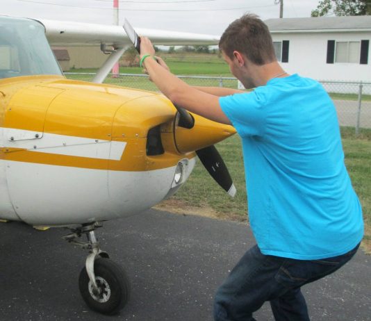 The alternative to bending down as the propeller is pulled through the compression stroke is to keep the back straight and bend the knees slightly, stepping away in a crouch. [Credit: LeRoy Cook]