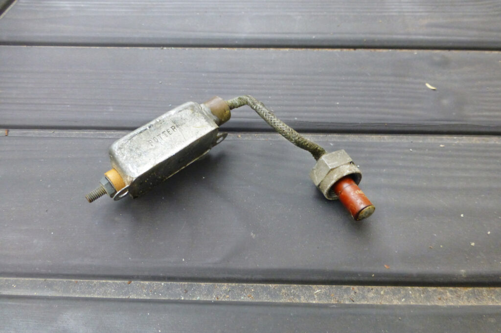 The noise filter and insert for the P-lead. The wire from the ignition switch goes to the small terminal on the left. Shielded wire with the insert goes into the opening shown in the prior figure.