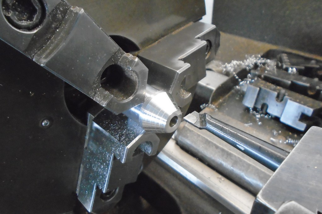 This pushrod insert was fabbed on both the lathe (initial turning and threading) as well as a mill with a rotary table (radial pocketing).