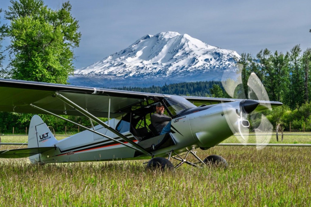 Backcountry manners intact: the ULT sits on a grass strip with the turbine spun up, built on the STOL-capable Carbon Cub UL airframe. [Credit: CubCrafters]