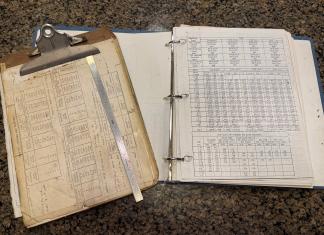 My 36 year old clipboard from when I started at Boeing. Engineering ruler and fastener/fastener hole cheat sheets. [Credit: Andrew Robinson]