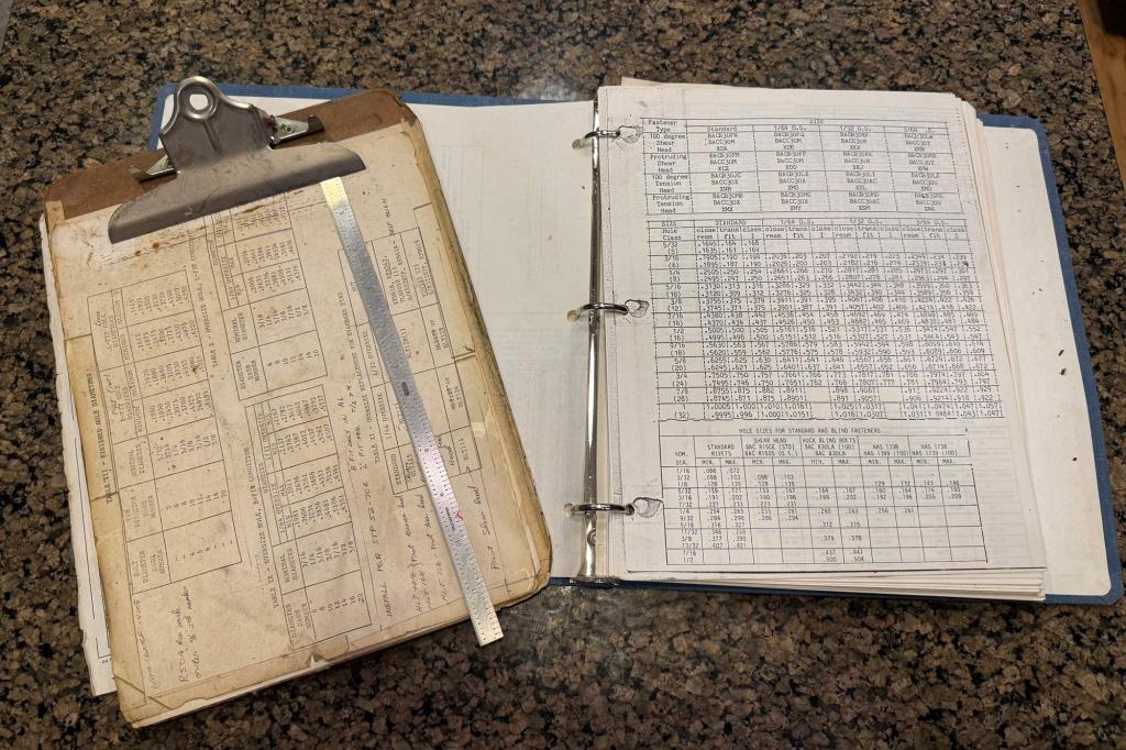 My 36 year old clipboard from when I started at Boeing. Engineering ruler and fastener/fastener hole cheat sheets. [Credit: Andrew Robinson]
