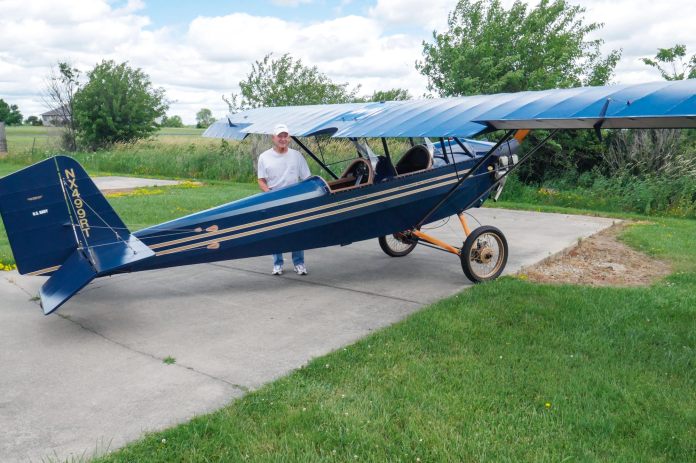 R.T. Searfoss shows off his magnificent workmanship in the Pietenpol Air Camper he built over the span of 12 years. There is much to love in classic tube and fabric aircraft which harken back to an earlier time of aircraft construction. Masterful craftsmanship is everywhere you look in R.T.’s work. [Credit: Bill Wilson]