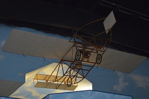 Wood-and-fabric Epps 1912 monoplane replica suspended in a museum hangar